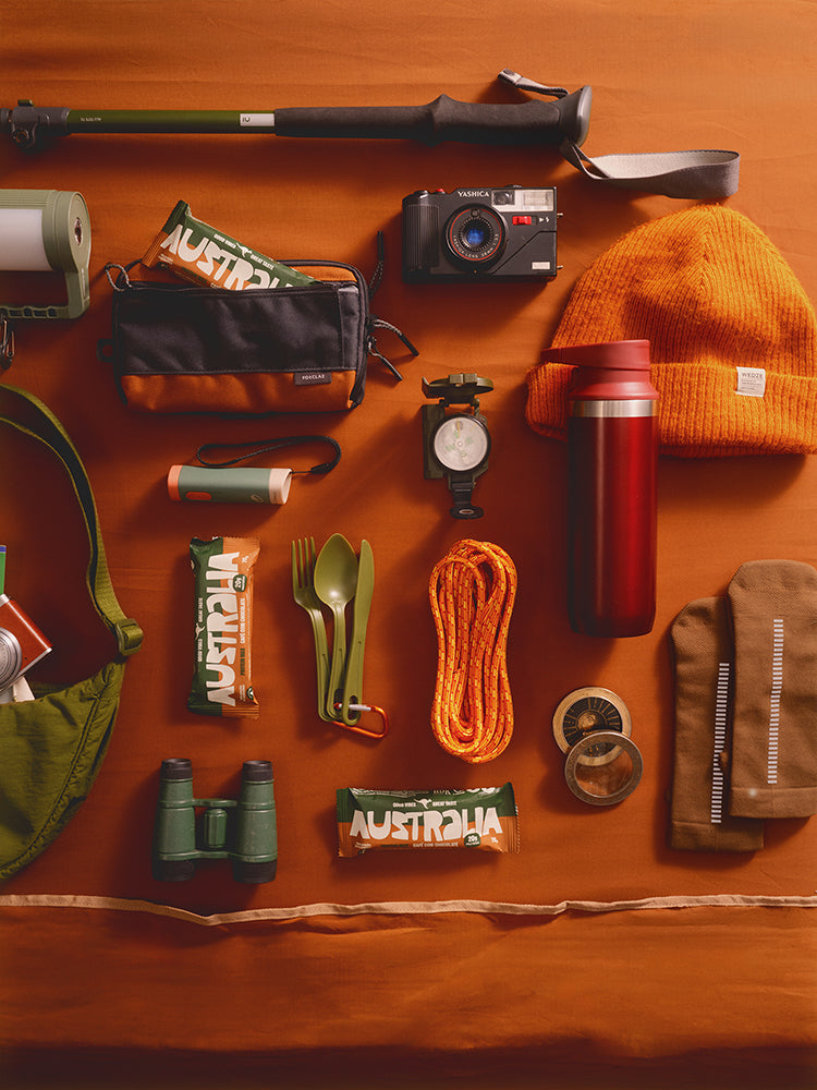 Barras de proteína AUSTRALIA entre equipamentos de trilha vistos de cima.