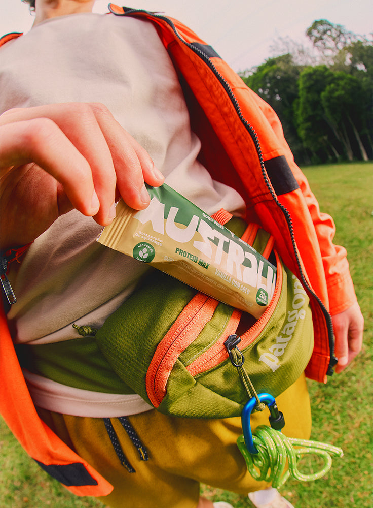 Pessoa retira uma barra de proteína AUSTRALIA de uma mochila.