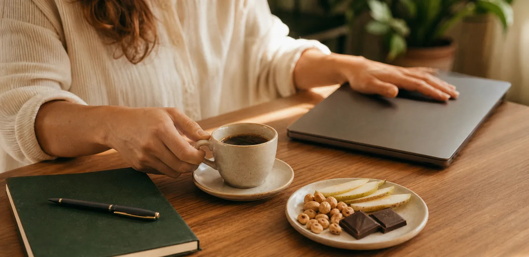 Pessoa em pausa com café, pera, castanhas e snack de cacau.
