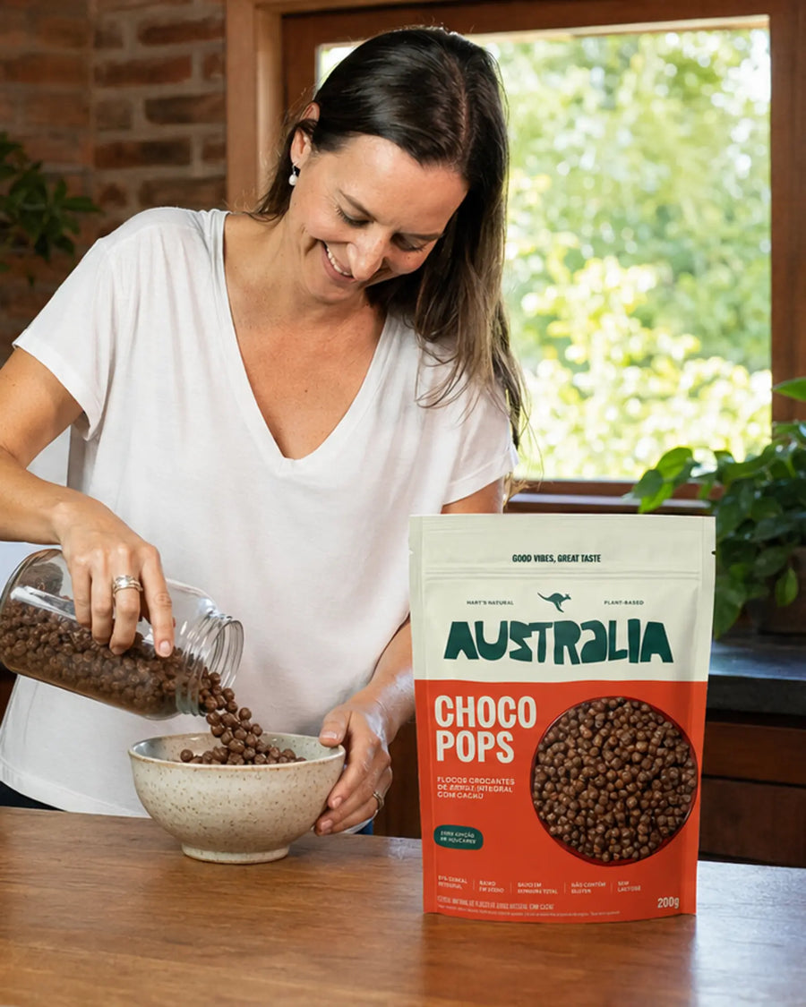 Raquel despeja ChocoPops de um pote de vidro numa tigela na bancada, com um pacote de ChocoPops ao lado.